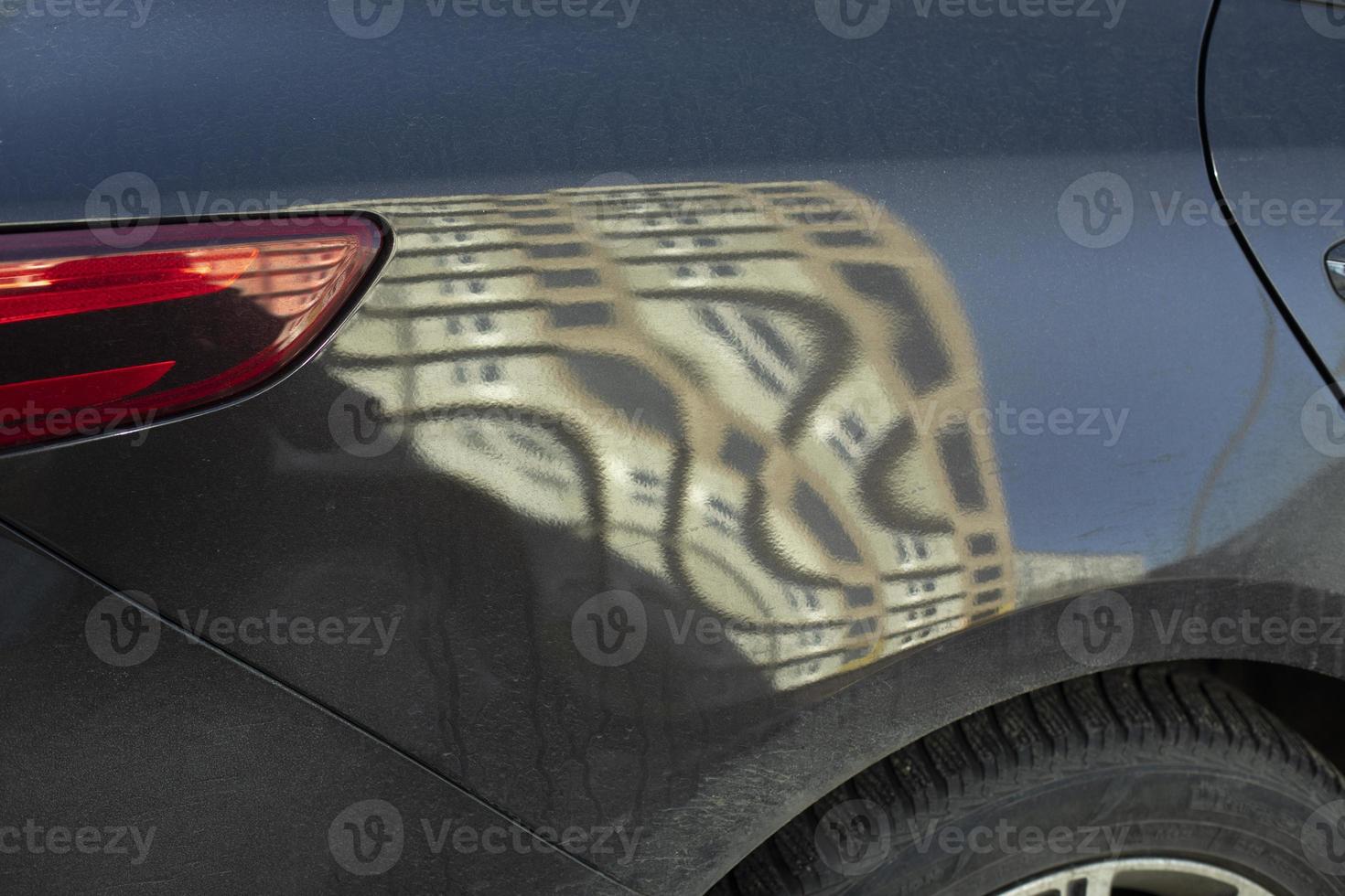 They drove car from behind. Reflection in surface of machine. Wheel and headlight. photo