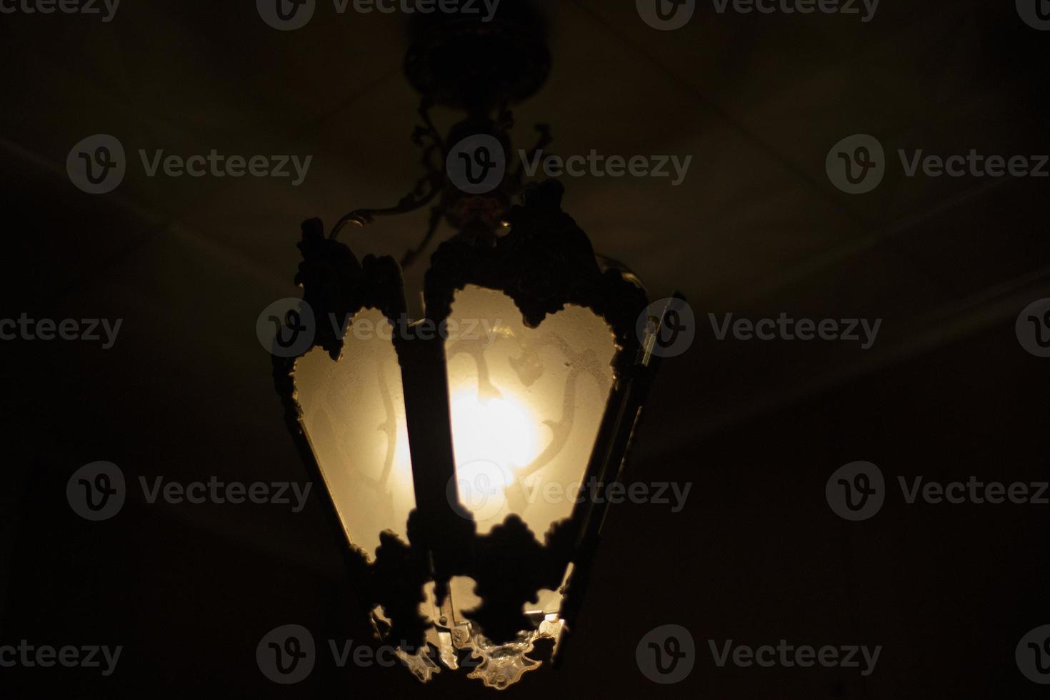 Lamp in dark. Light source. Old chandelier. photo