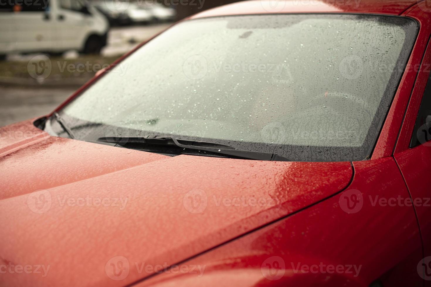 carro rojo. coche mojado en el estacionamiento. foto