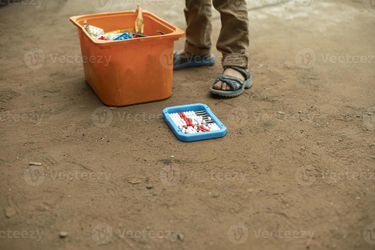 Child with box of toys on street. Boy plays. photo