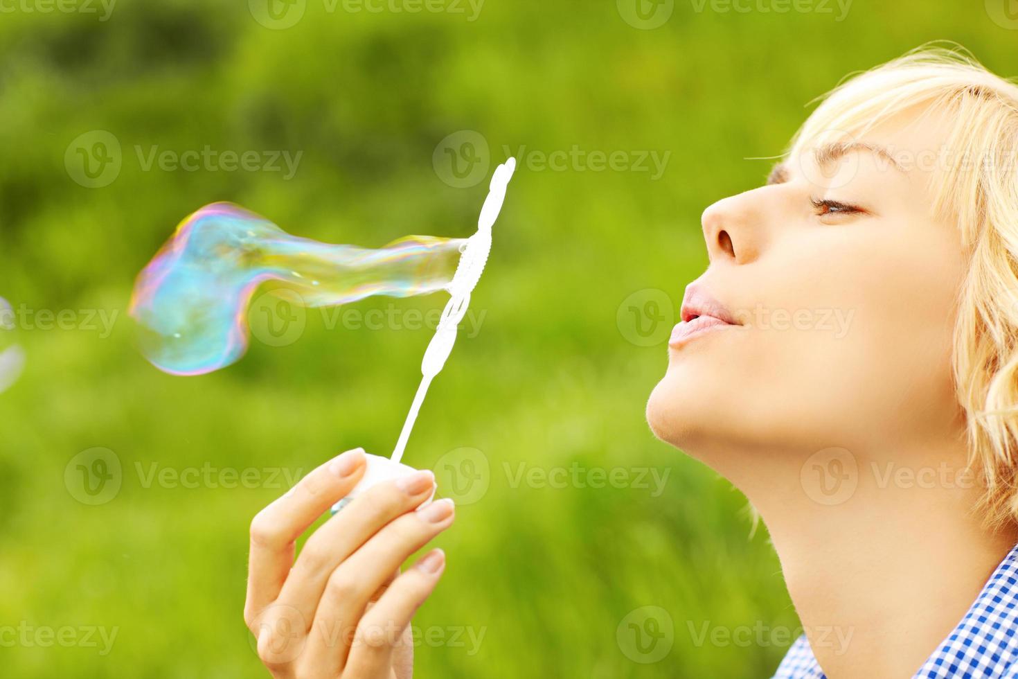 Woman blowing bubbles photo