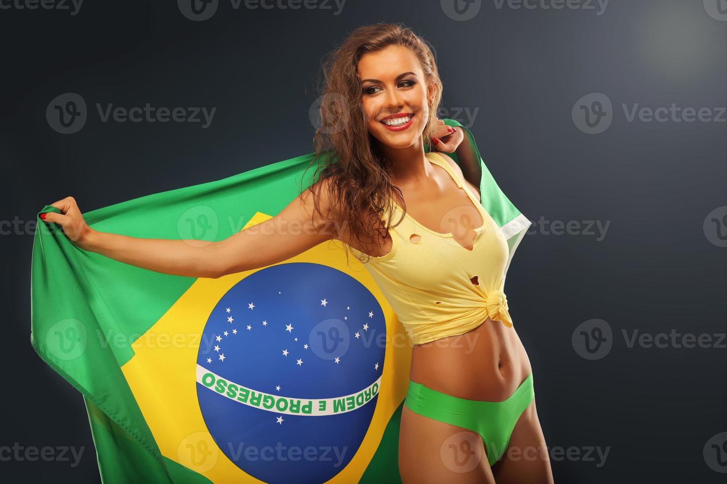 Happy Brazilian fan cheering with flag photo