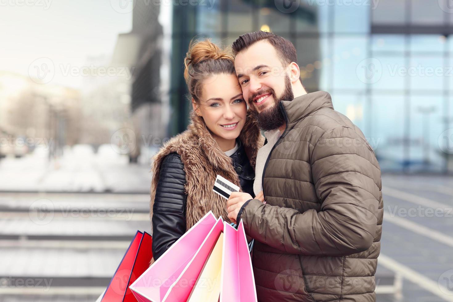 pareja joven de compras en la ciudad con tarjeta de crédito foto