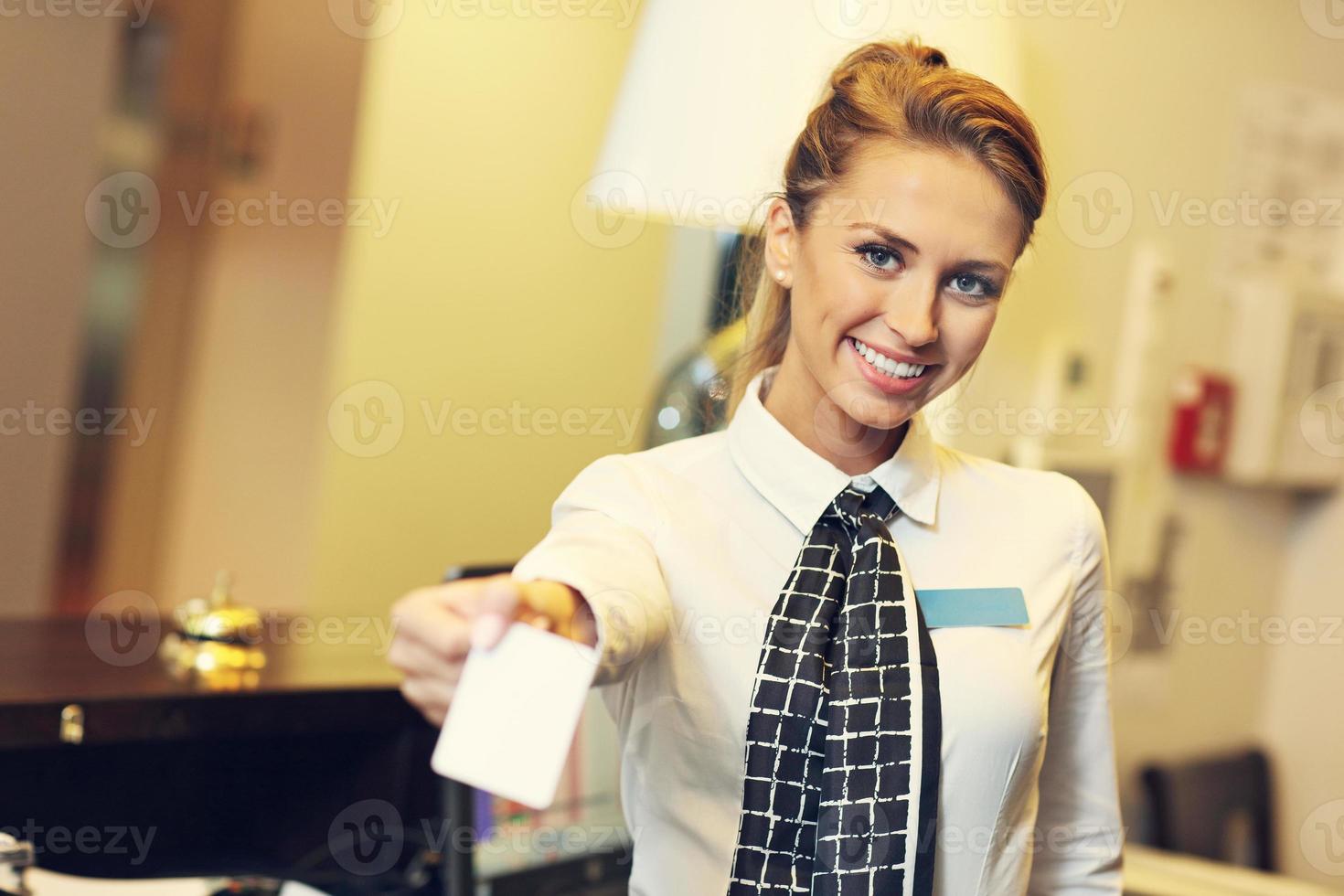 bonita recepcionista dando tarjeta llave foto