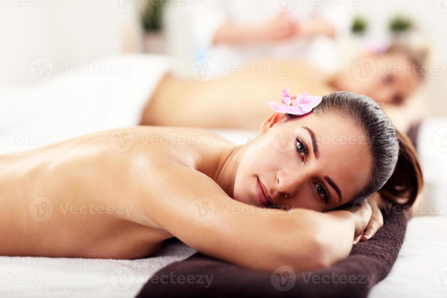 Two beautiful women getting massage in spa photo