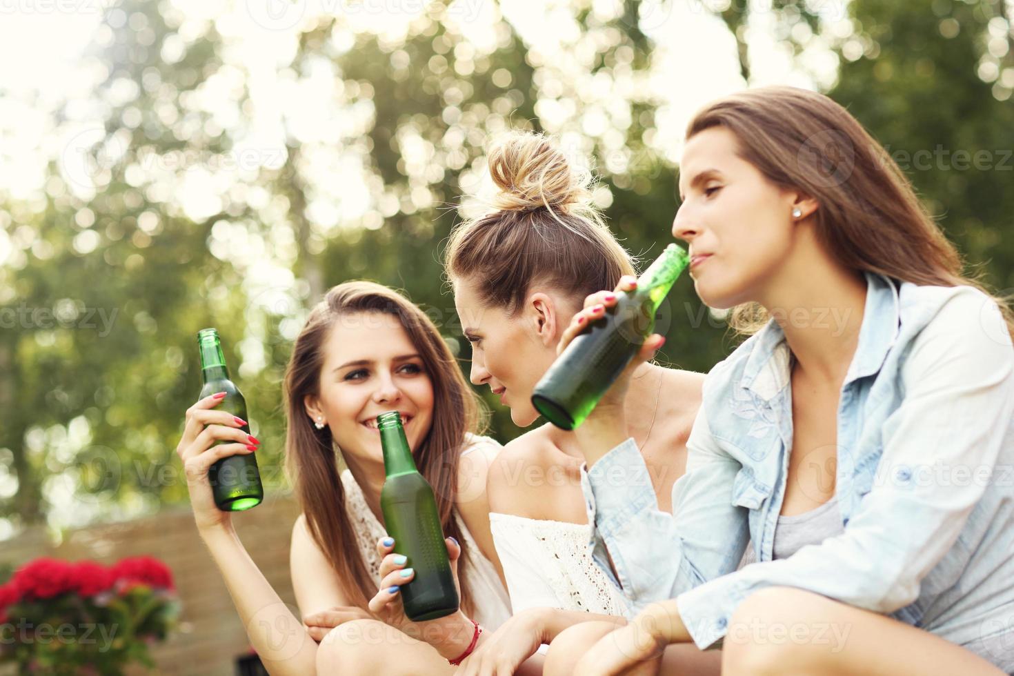 feliz grupo de amigos bebiendo cerveza al aire libre foto