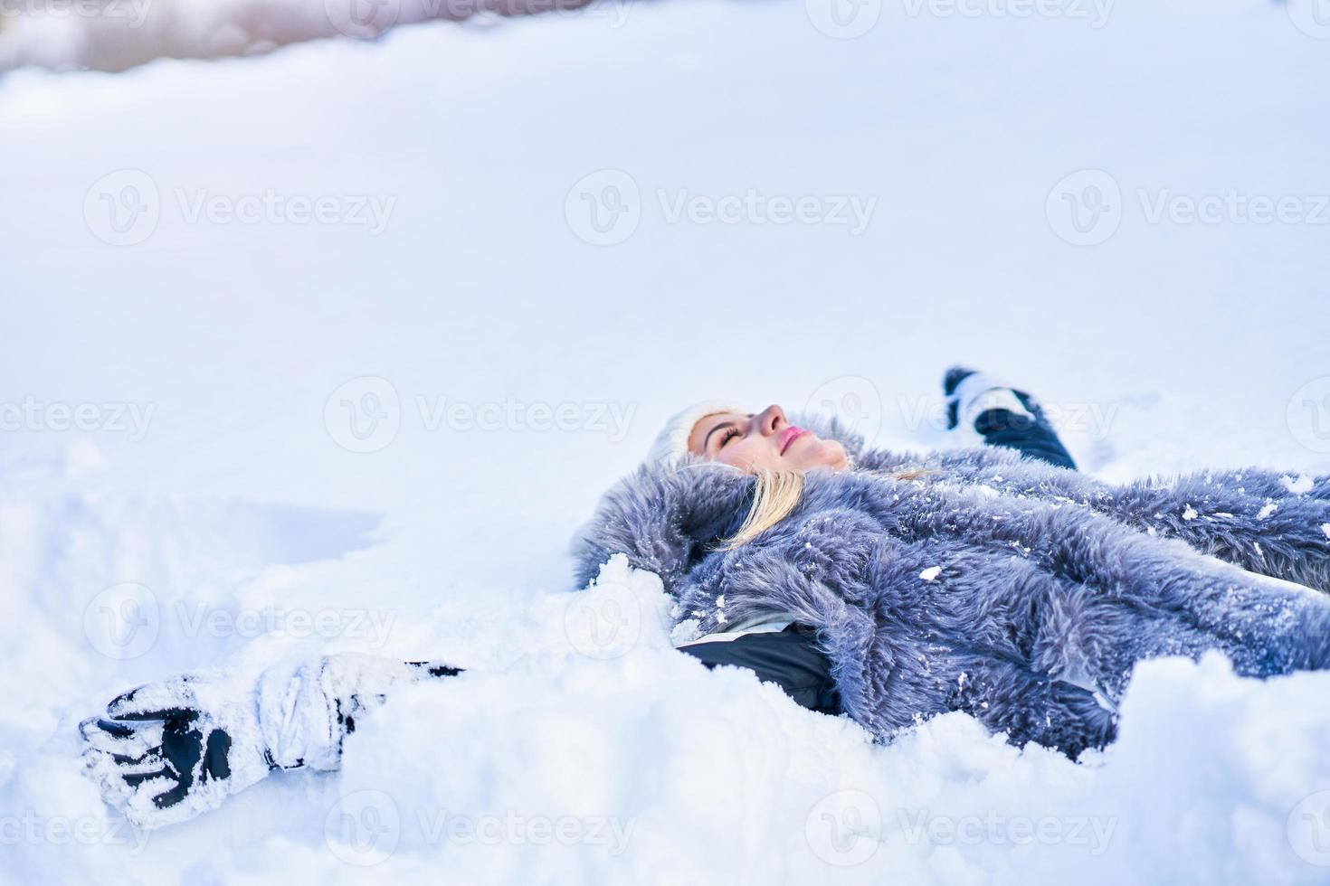 Young nice woman lying on the snow photo