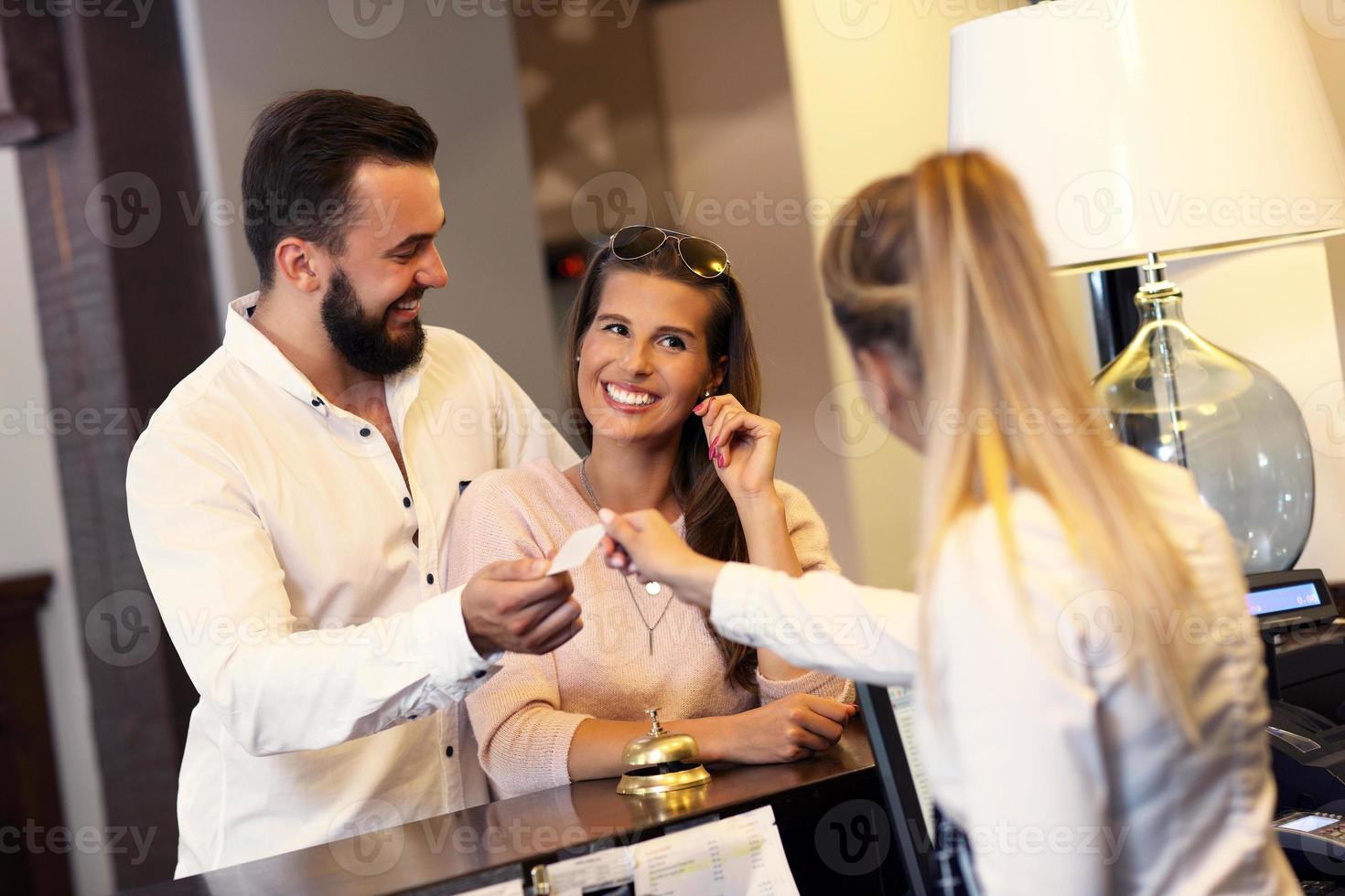 Couple at reception desk in hotel photo