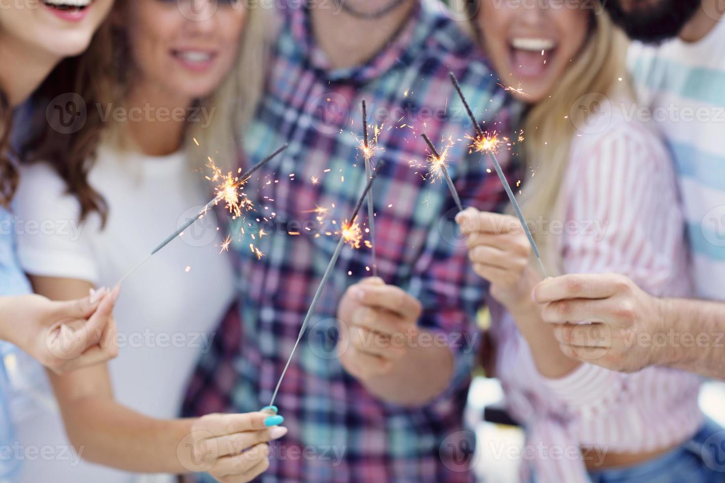 Group of friends having fun with sparklers photo