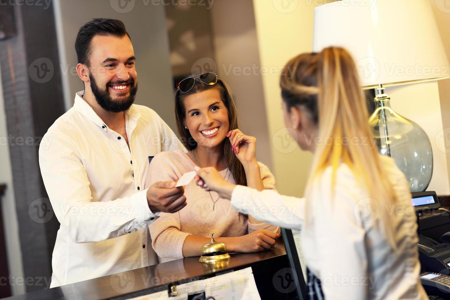 Couple at reception desk in hotel photo