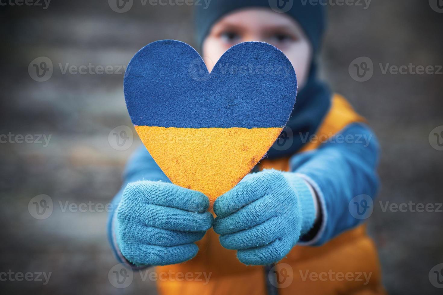 Picture of a child with a lot of love and peaceful message holding heart photo