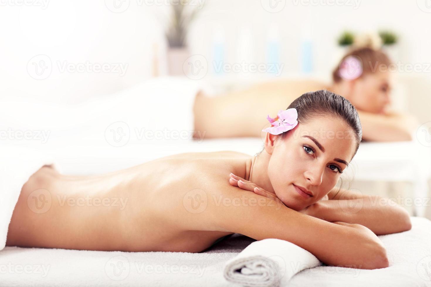 Two beautiful women getting massage in spa photo