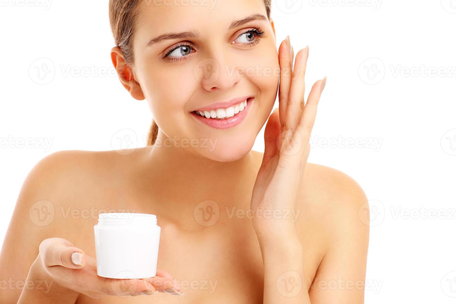 Pretty woman applying cream on face photo