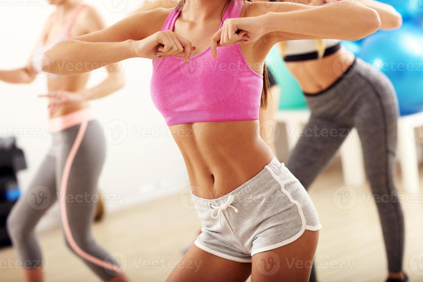 Group of happy people with coach dancing in gym photo