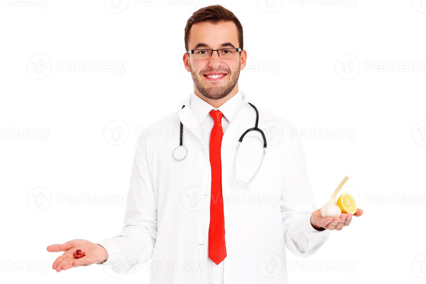 Doctor showing pills and garlic with lemon photo