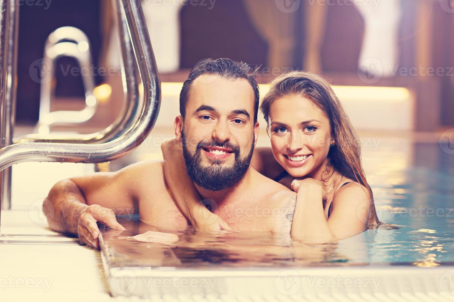 Happy couple relaxing in pool spa photo