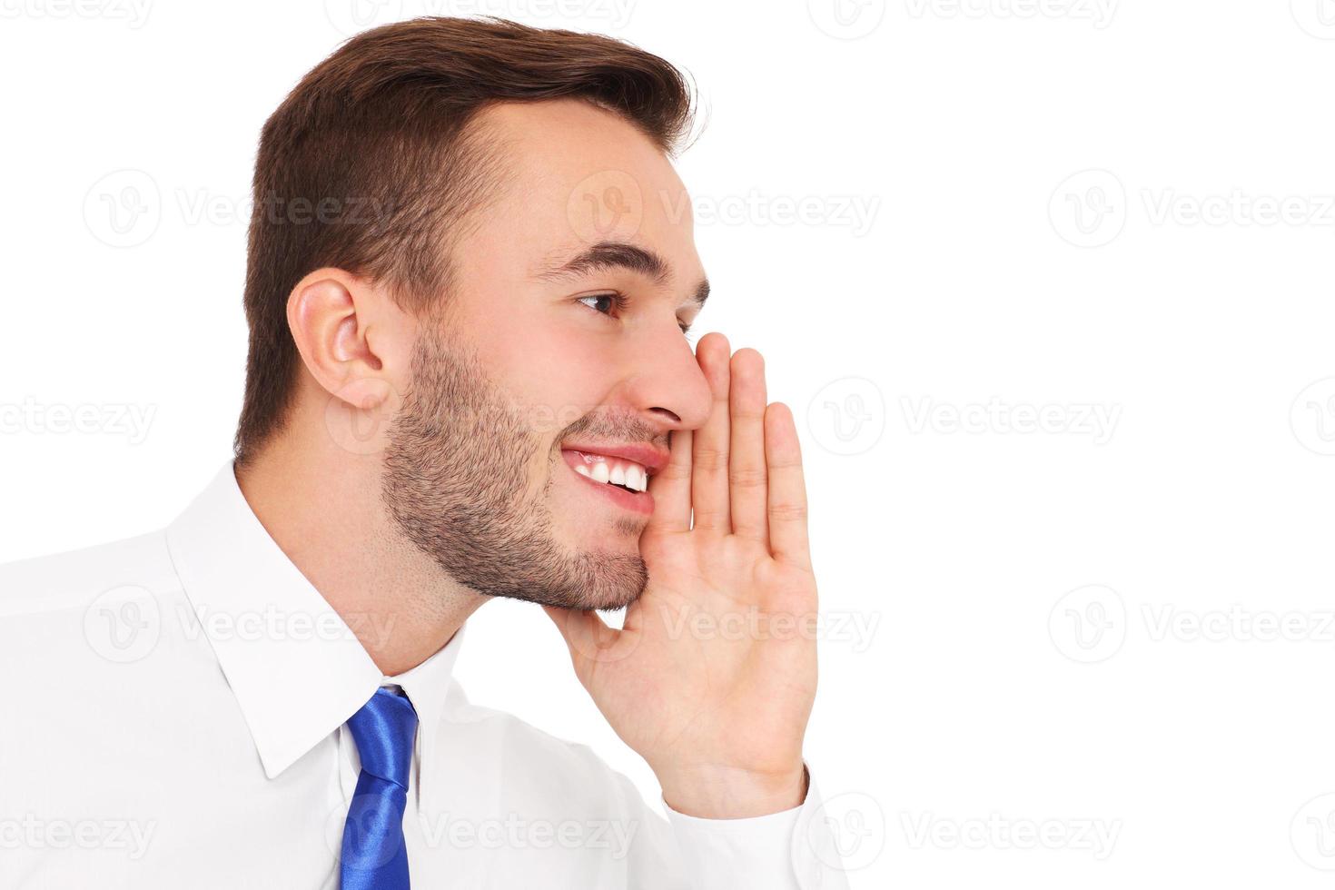 Young businessman whispering over white background photo