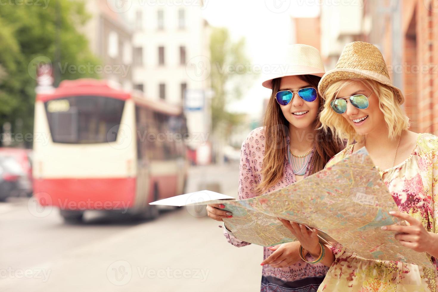 Two friends using map in the city photo