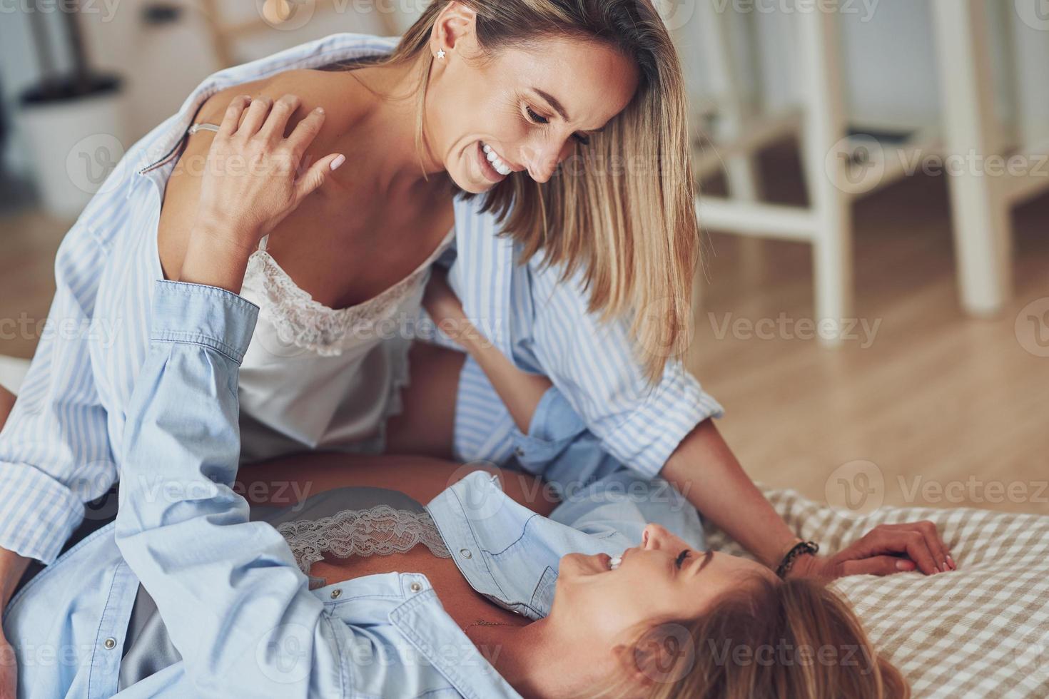 Two young girlfriends on the bed photo