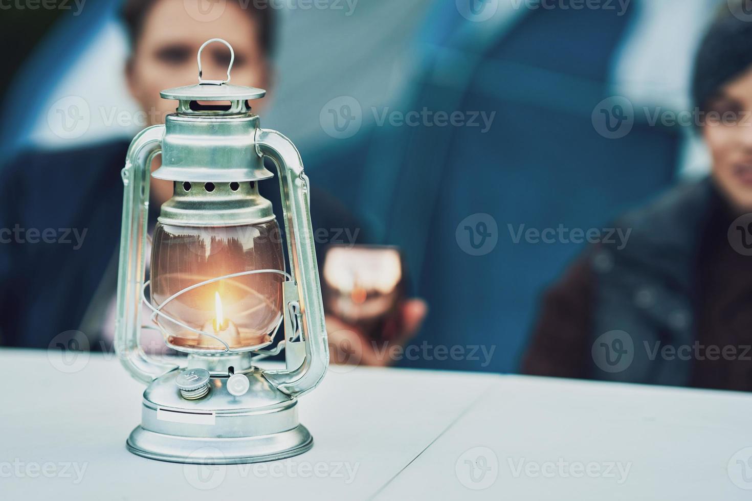 Young nice couple having fun on camping with kerosene lamp photo
