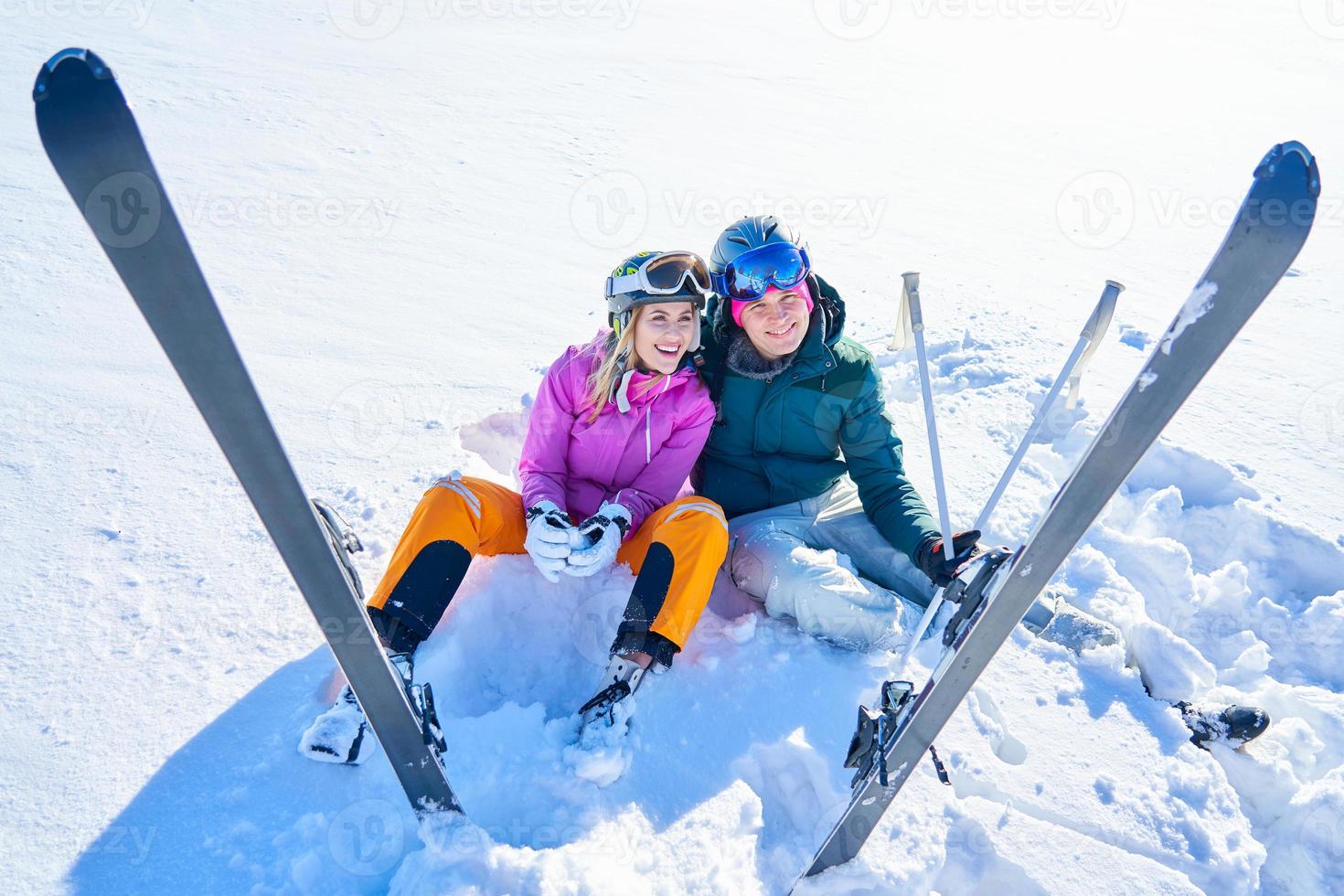 pareja joven divirtiéndose mientras esquía en invierno foto