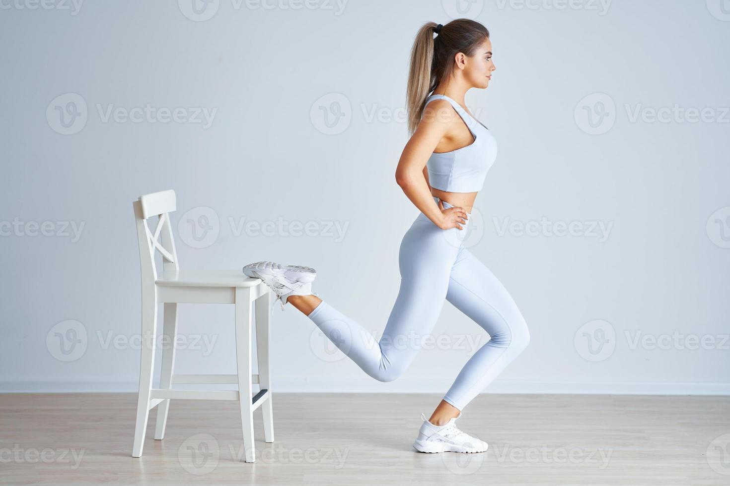 Adult beautiful woman working out over light background photo