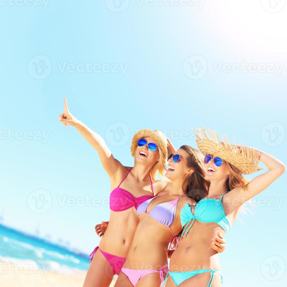 Group of women pointing at something on the beach photo