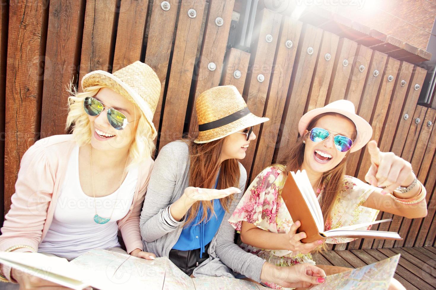 Group of joyful tourists using map in the city photo