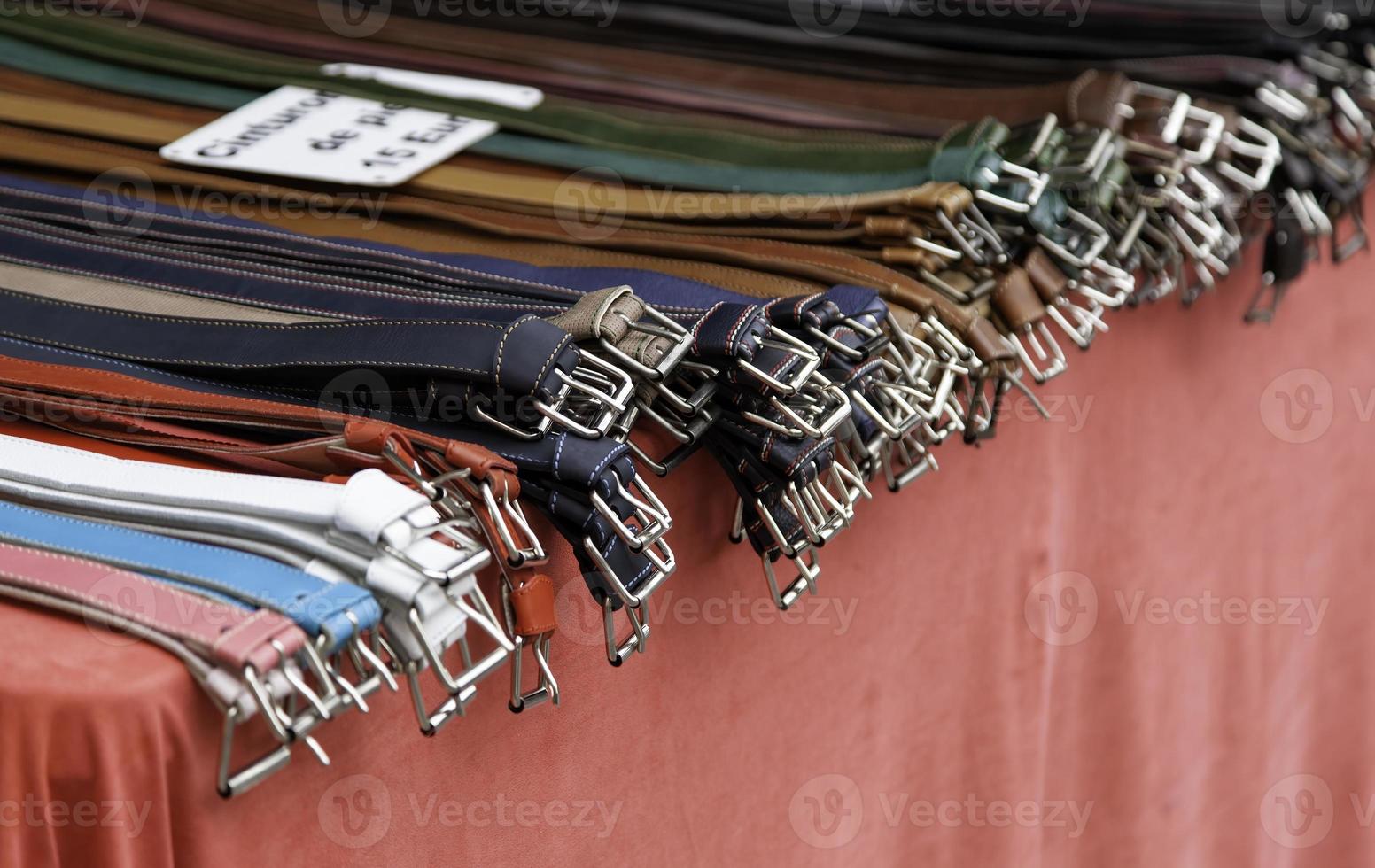 Leather belts in a market photo