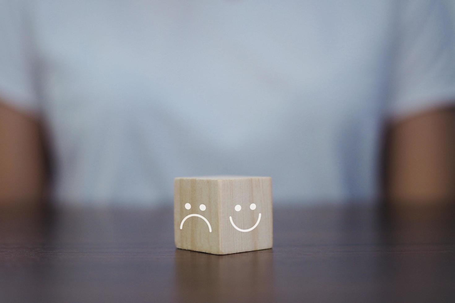 estado emocional caras sonrientes y caras tristes en cubos de madera. foto