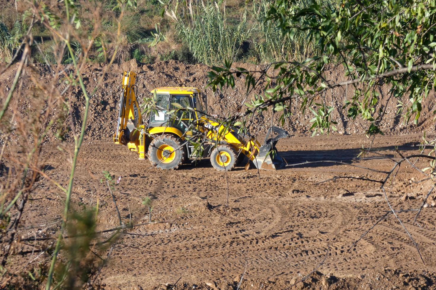backhoe loader standing on a dirt field photo
