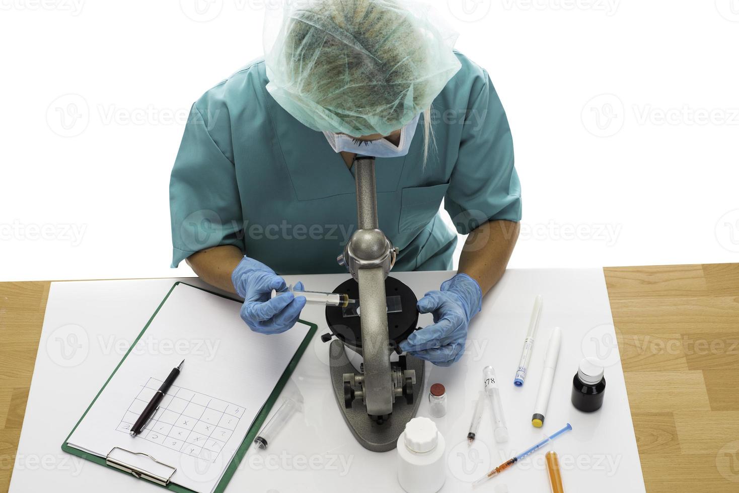 Scientist in blue medical gloves and uniform learning COVID-19 samples with microscope in laboratory. photo