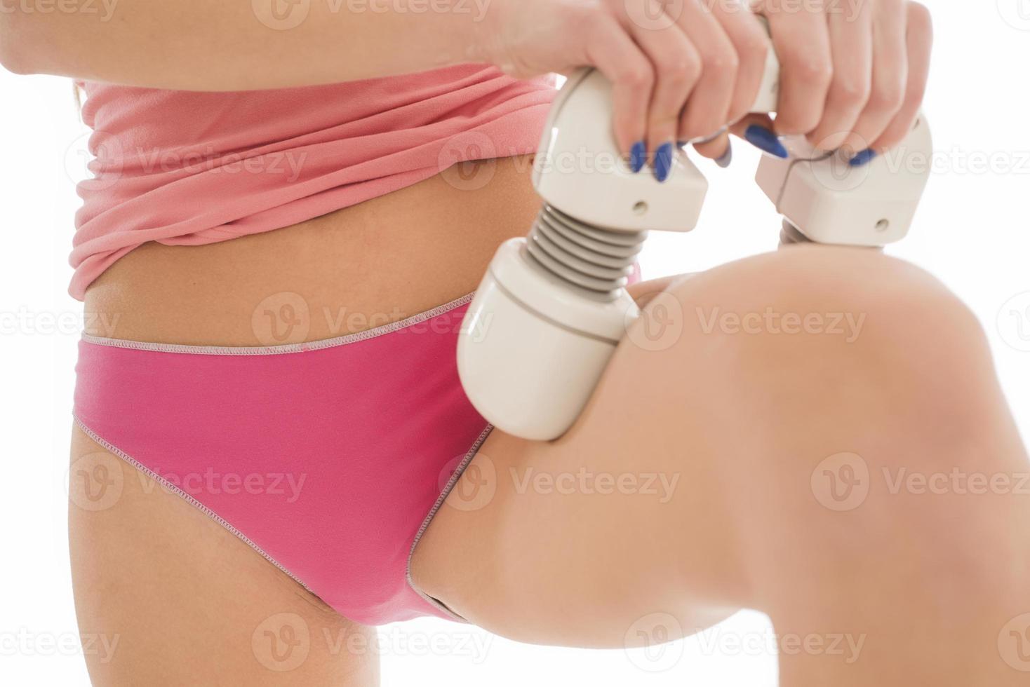 Unknown female with perfect shaped body massaging her hips with electric massager photo