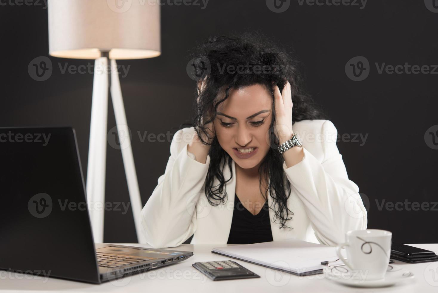 tired business woman trying to work in her office photo