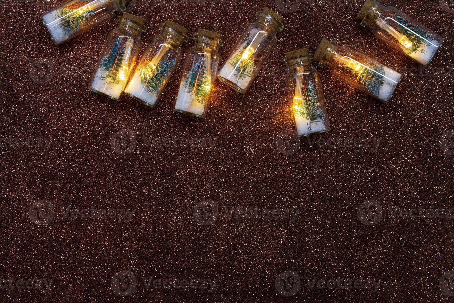 Light bulbs inside with Christmas tree and snow on brown shiny background. Christmas, New Year. Copy space photo