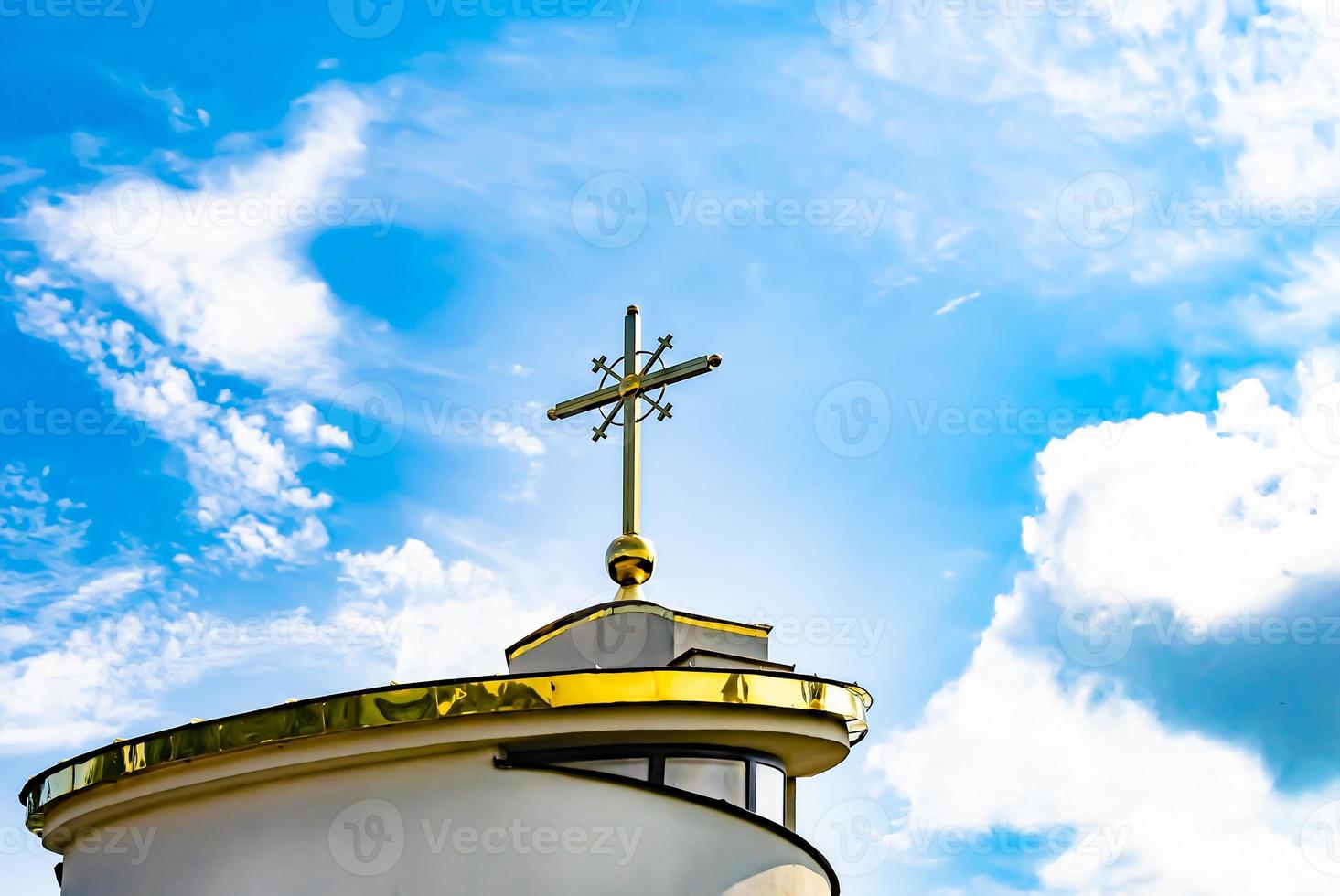 Cruz de la iglesia cristiana en alta torre campanario para la oración foto