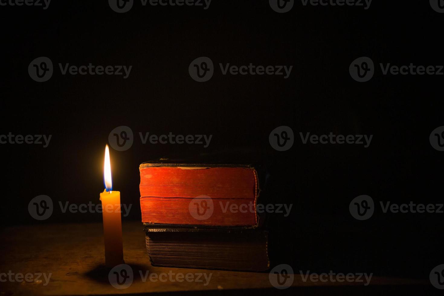 Light candle with holy bible and cross or crucifix on old wooden background in church.Candlelight and open book on vintage wood table christianity study and reading in home.Concept of christ religion photo