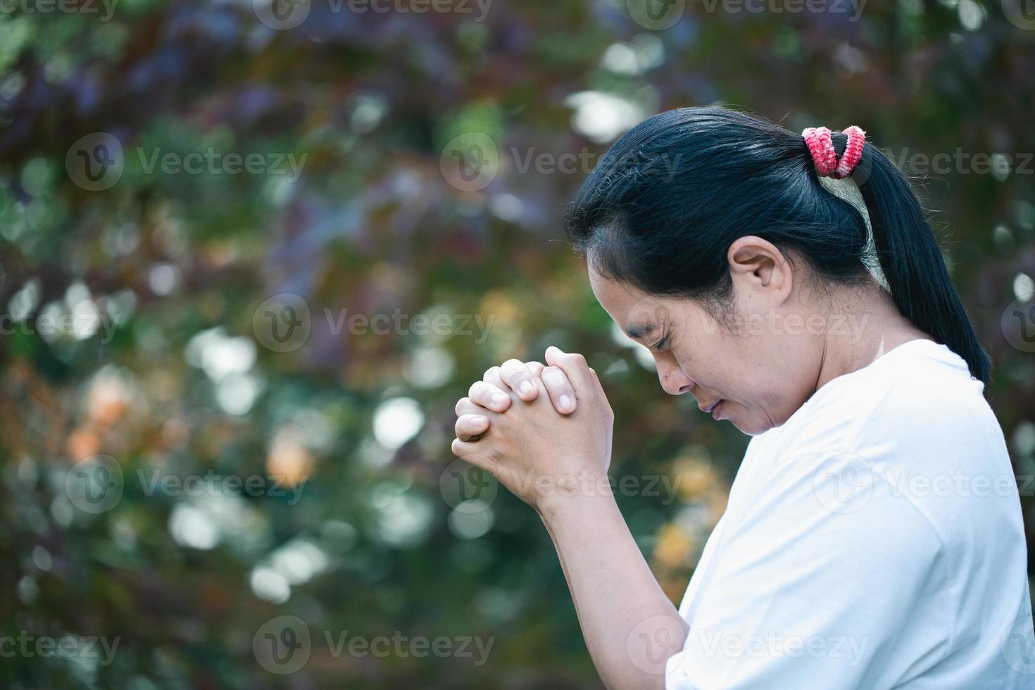 Prayer person hand in black background. Christian catholic woman are praying to god in dark at church. Girl believe and faith in jesus christ. Christ religion and christianity worship or pray concept. photo