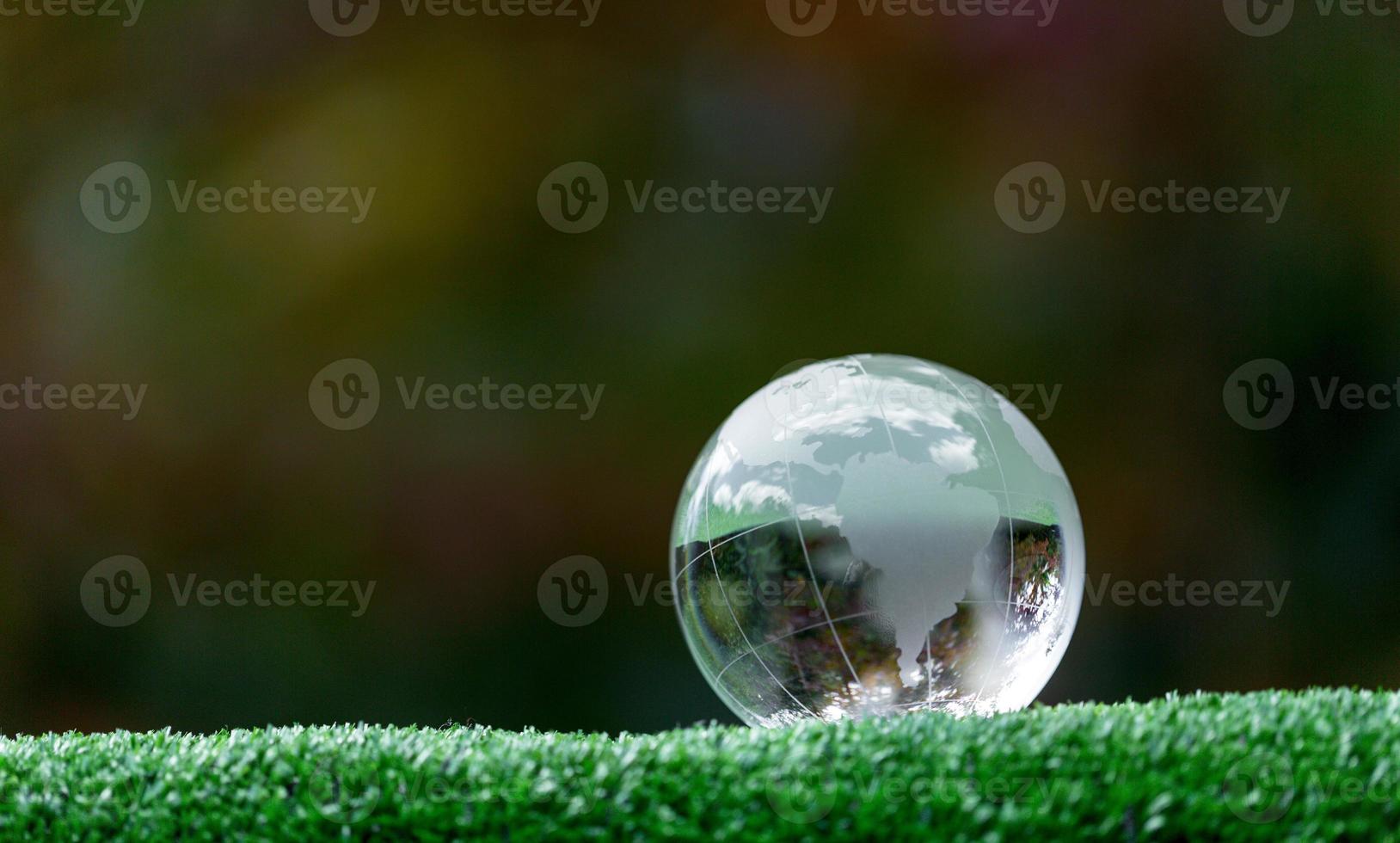 Close up of crystal globe resting on grass in a forest - environment concept photo