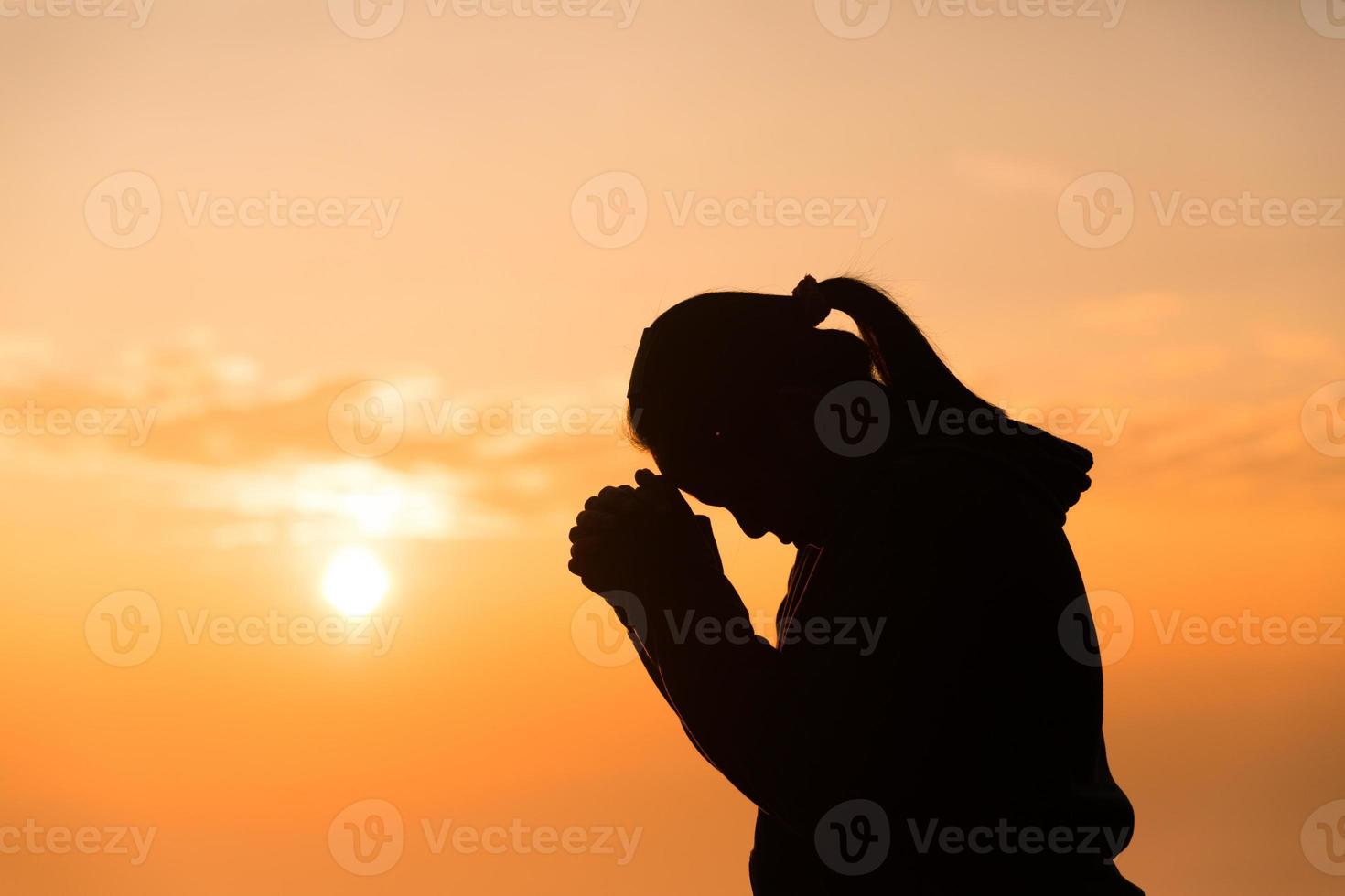 concepto persona cristiana adorar o rezar a dios. silueta de mujer cristiana con amor, fe, devoción a dios con fondo de cielo de amanecer. adorar a dios por la paz, la victoria, el éxito con esperanza. religión foto