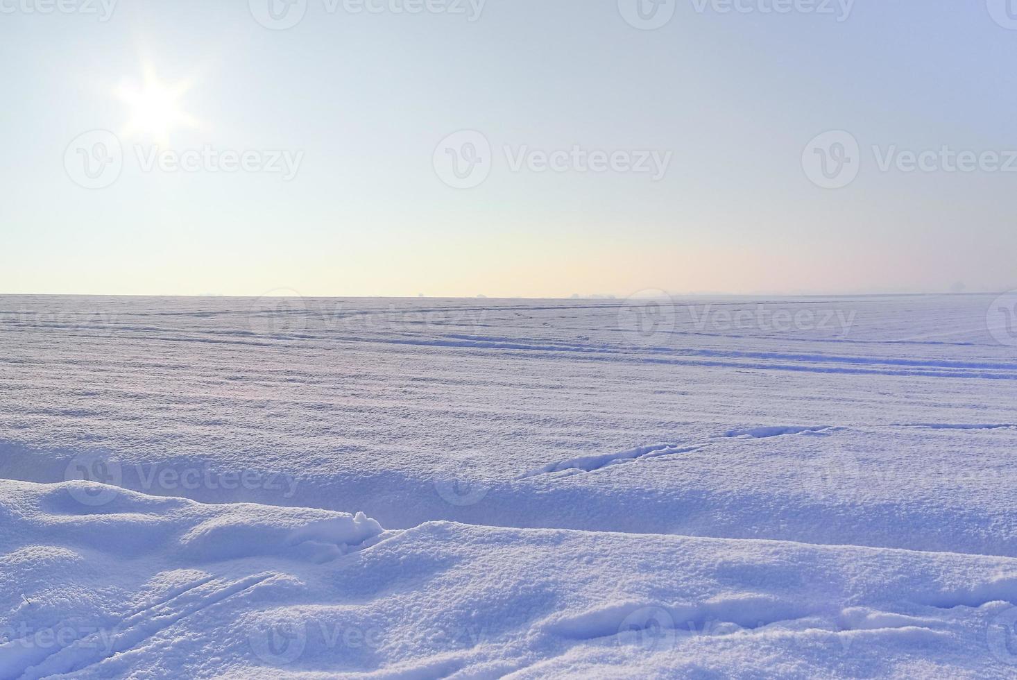 A white snow-covered piece of farmland in winter on a sunny day. photo
