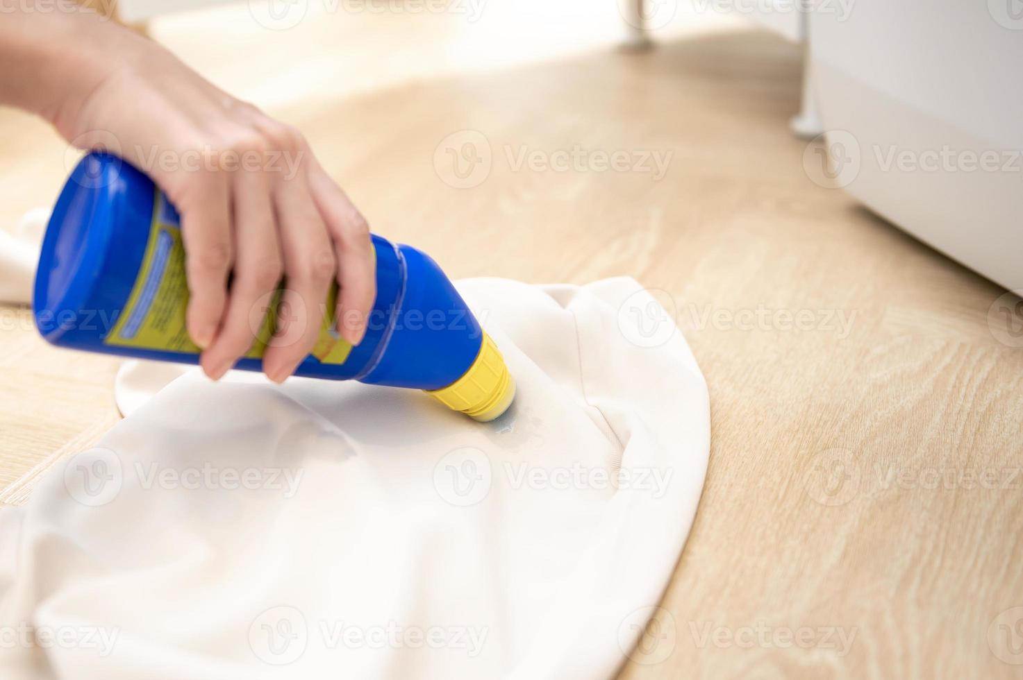 Close-up female hand applying detergent to remove severe stains in clothes photo