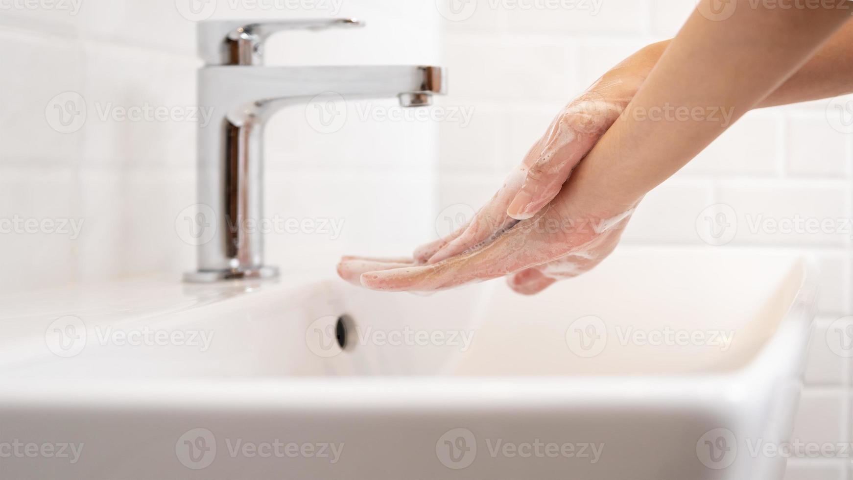 Woman washing her hands  in the bathroom at home photo