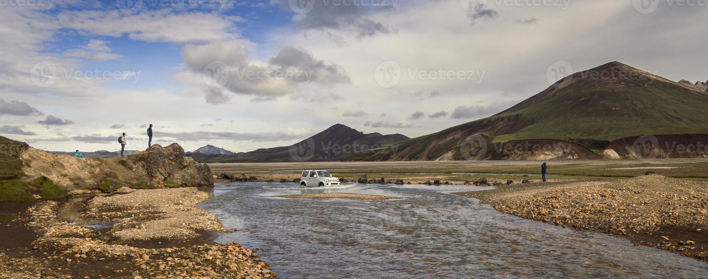 Car crossing shallow river landscape photo