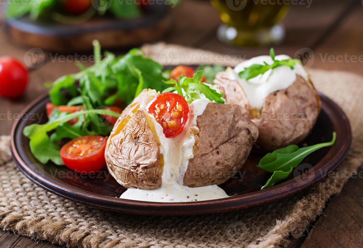 Baked potato filled with sour cream, arugula and tomatoes photo