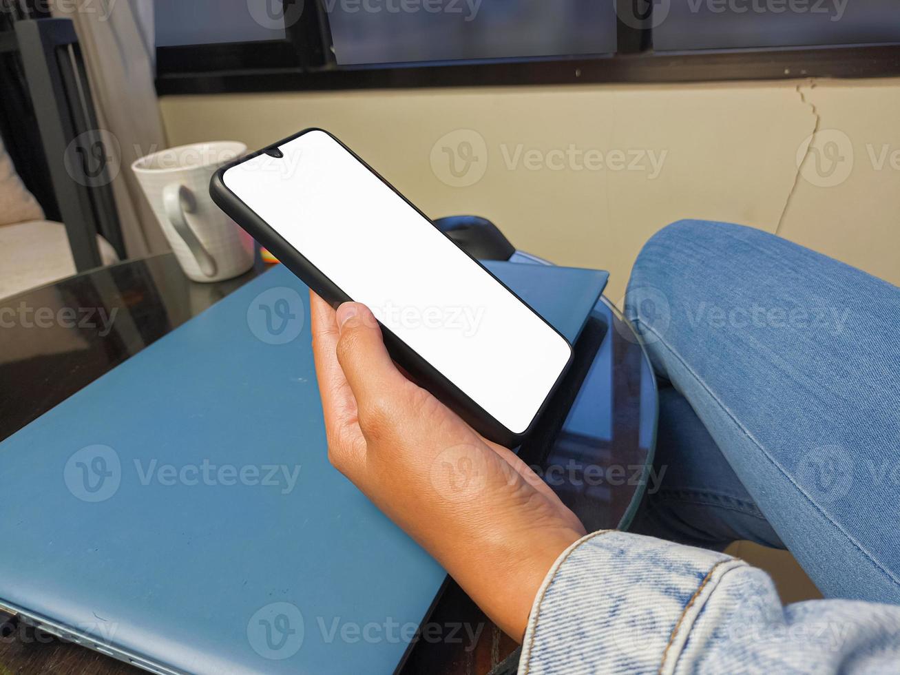 Close-up of a woman hand holding a smartphone white screen is blank .Mockup. photo
