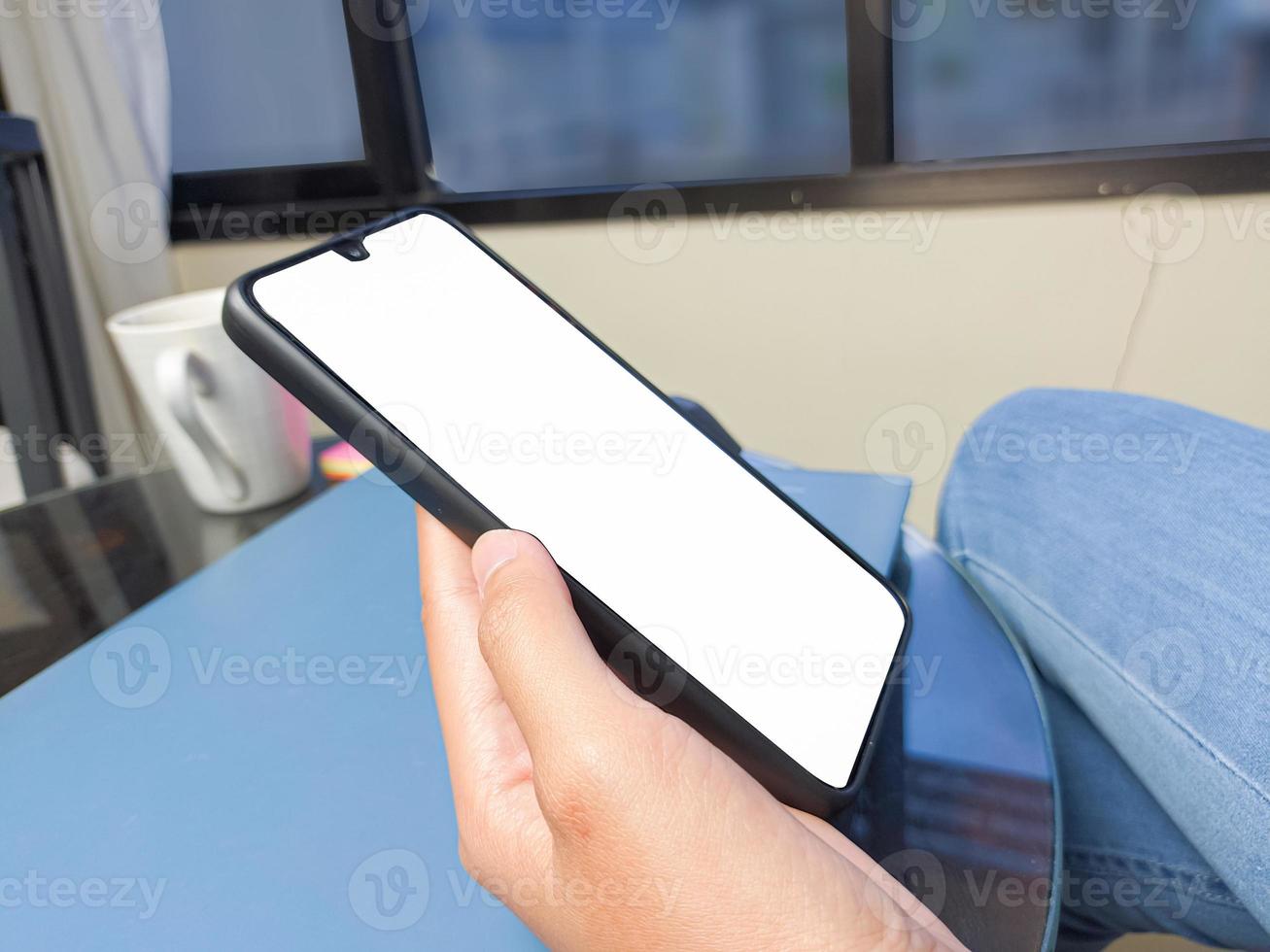 Close-up of a woman hand holding a smartphone white screen is blank .Mockup. photo