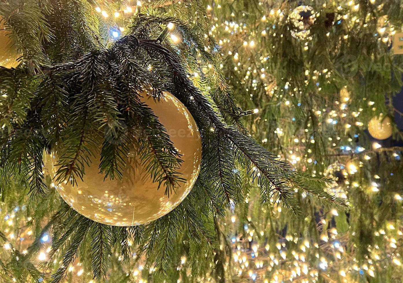 Christmas banner with copy space and sparkles for greeting card. Fir branch with red balls, festive yellow lights and bokeh. Perfect content for advertising banners, gift card or creative projects. photo