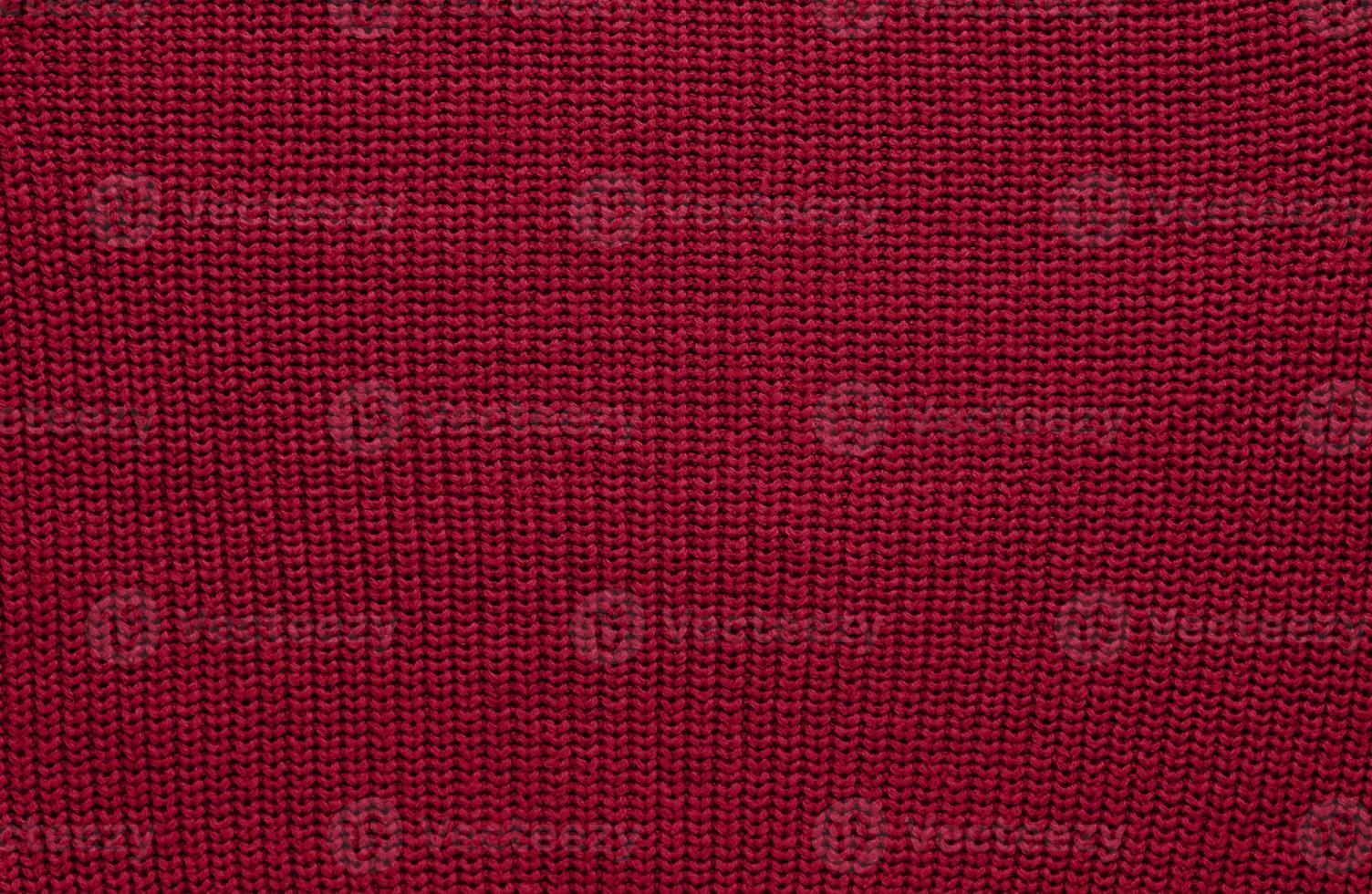 Texture of smooth knitted sweater with pattern. Handmade knitting wool or cotton fabric texture. Background of Large knit pattern with knitting needle or crochet. Color Of The Year 2023 - Viva Magenta photo