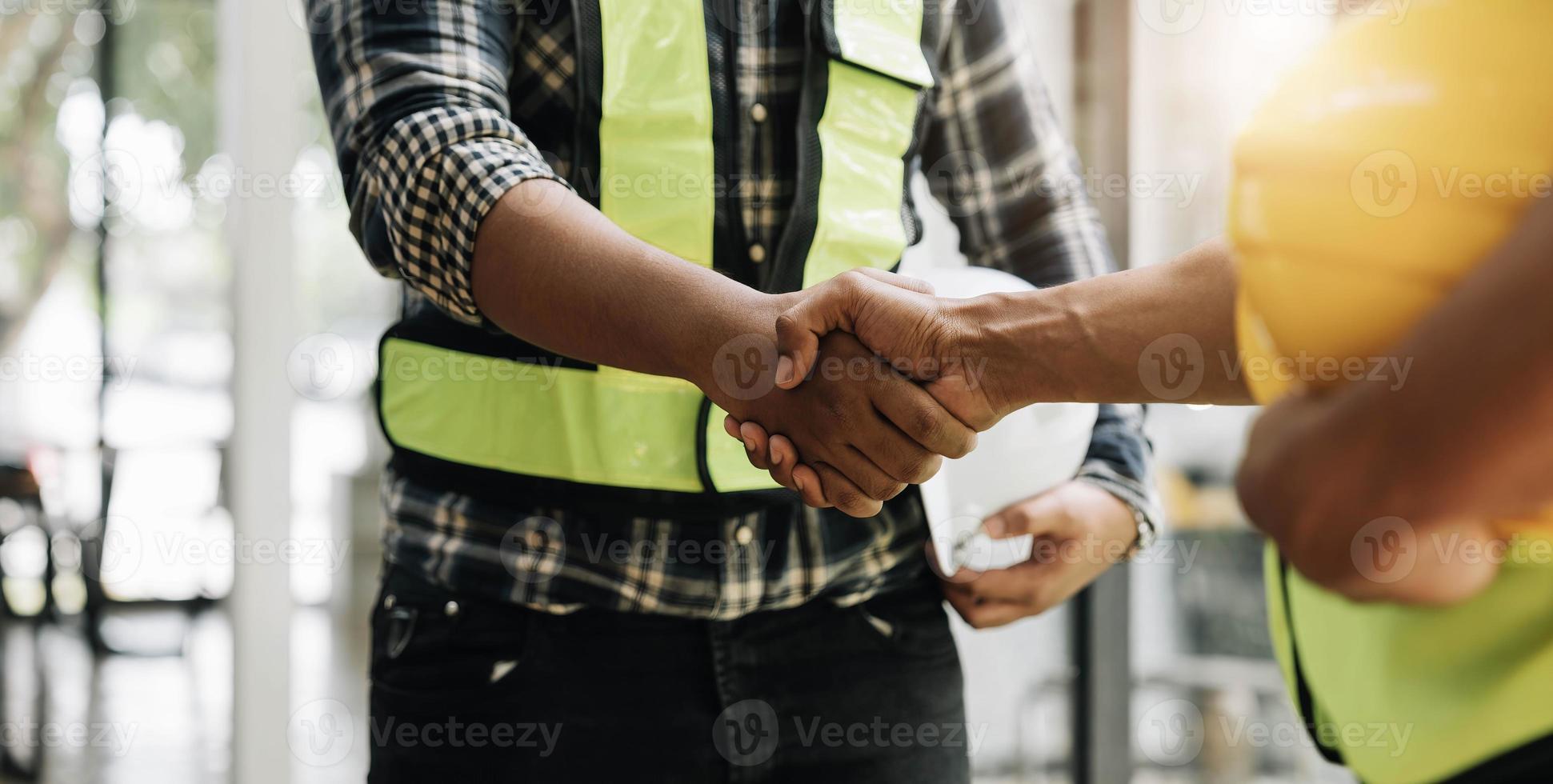 manos del equipo de trabajadores de la construcción temblando después de la reunión de consulta para saludar el plan de inicio nuevo contrato de proyecto en la oficina foto